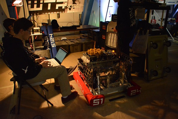 FIRST® Robotics team programs their robot in the pit