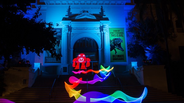 Nighttime building lit up with LED light art and Maker Faire® robotic logo