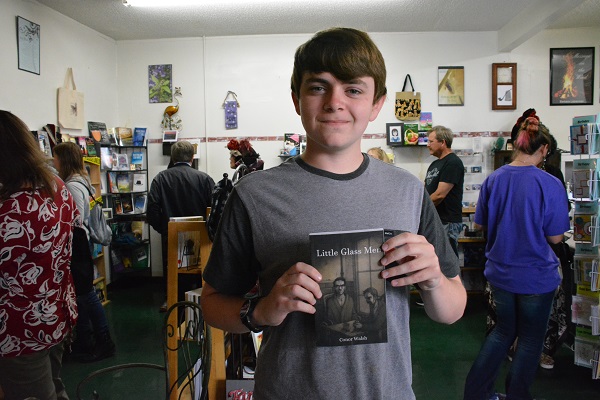 Author Conor Walsh displays his book Little Glass Menin the center of Pipe & Thimble Bookstore