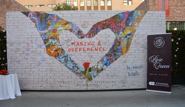 wall backdrop with "Making a Difference" in hands shaped like a heart