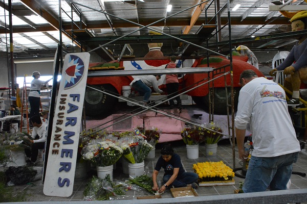 Volunteers cut and glue flowers for Farmers Insurance float