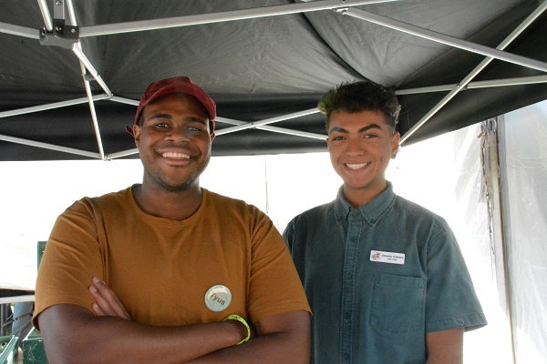 Engineering students Tyus Robinson and Orlando Cabrera staff the merchandising tent for the Cal Poly Rose Float