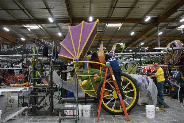 Volunteers work on carriage float with soda bottles