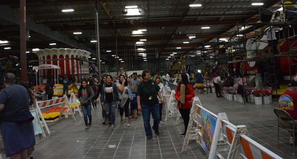 guests walk through center aisle surrounded by floats at Rose Plaza South