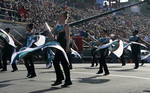 BOSS flag dancers wave aqua and white flags before reviewing stand