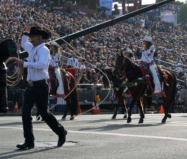 Broken Horn Roper man in cowboy attire performs rope tricks while Rodeo Queen rides a chestnut horse