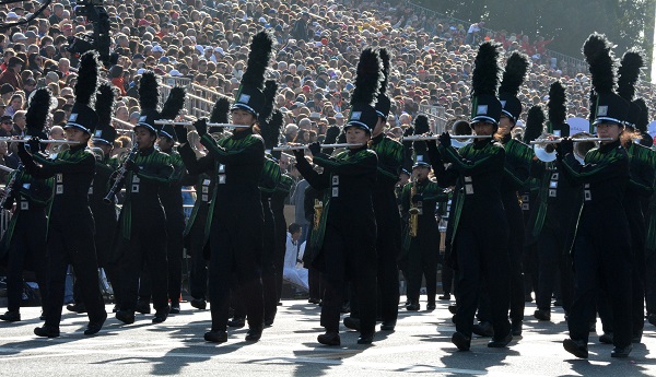 Homestead High musicians in black uniforms playing flutes at reviewing stand