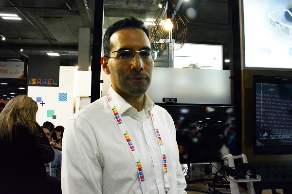 Tal Lotan, in a white shirt with "Israel" lanyard, displays his ICI Vision technology at CES® 2018