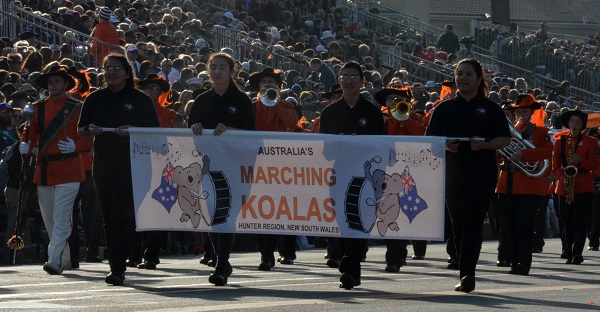 Marcching Koalas in orange and black uniformas approach Orange Grove and colorado