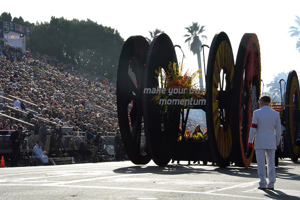 "Make Your Own MOmentum" Amazon Prime float apears in 2018 Rose Parade with White ASuiter watching