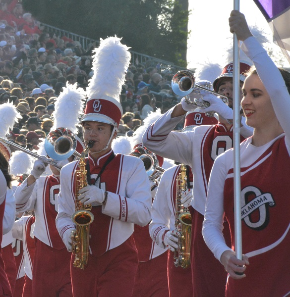 Oklahoma State band members in red-and-white uniforms, performing in the 129th Rose Parade