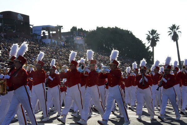 Pasadena City College Tournament of Roses Honor Band in white slacks and red jackets, playing as they walk by the reviewing stand