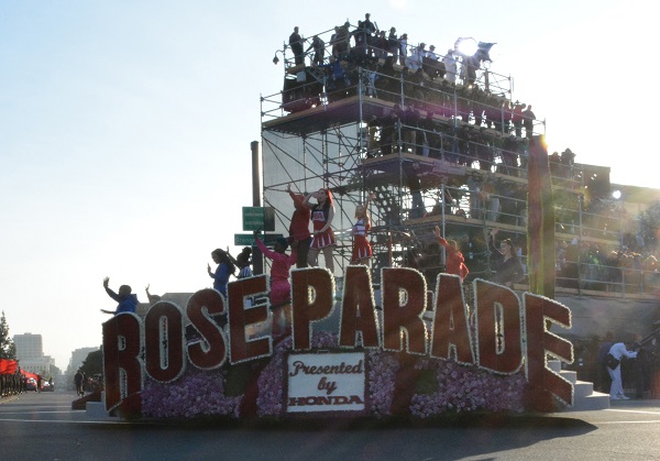 Rose Parade banner float with riders goes by TV corner