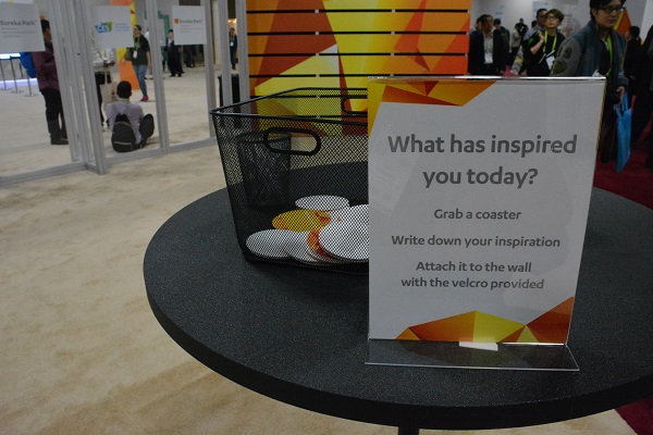 Sign asking,, "What inspired you?" and coasters on which to write an answer,with pens next to them