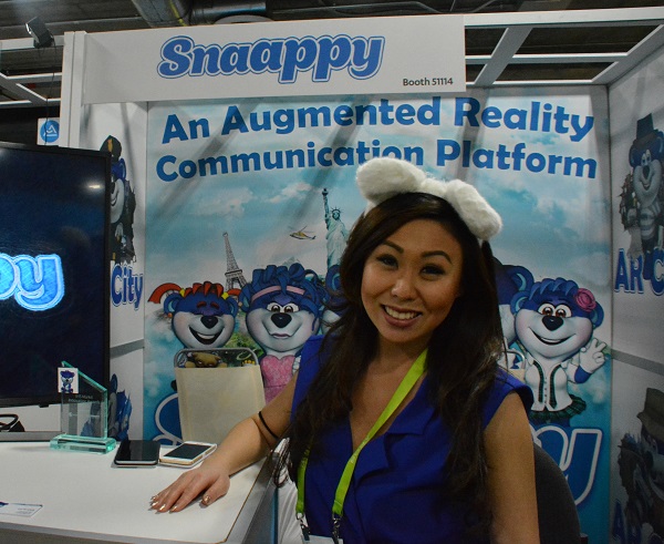 demonstrator with cat ears near "Snaappy" augemented-reality display wiht blue teddy bear