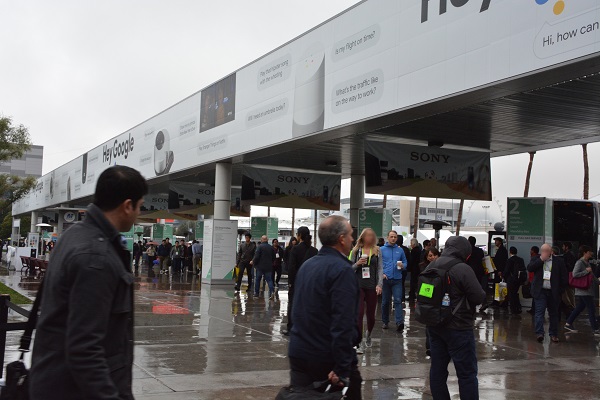 CES 2018 atendees walk through rain outside Las Vegas Convention Center