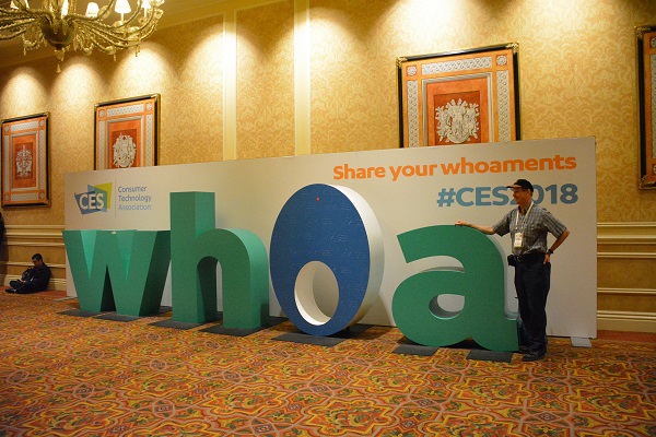 Man poses next to "Whoa" sign at CES 2018