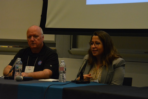 Dr. Ramaswamy speaks on a panel as Charles White listens