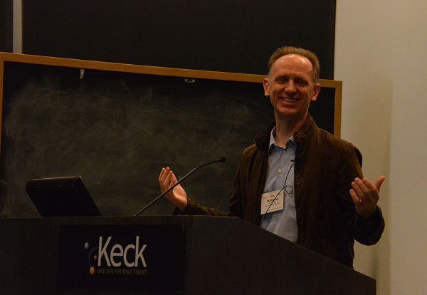 Dr. Wolfgang Stuerzlinger smiles as he extends his hands at the podium