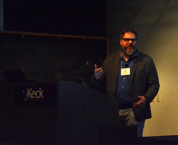 Dr. Dan Keefe discusses AR and VR next to a podium with Keck logo at Caltech