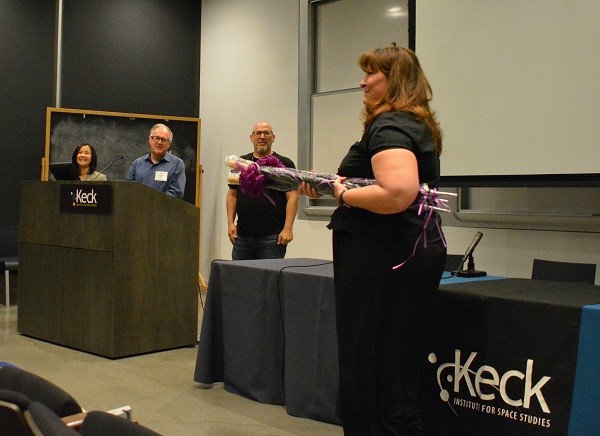 Michele Judd of Keck Institute for Space Studies comes onstage with gift-wrapped gift umbrellas