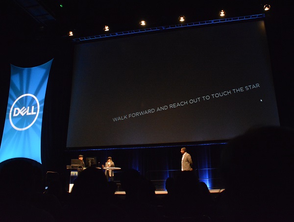 Eliza McNitt wears heaset onstage as she previews a VR film clip at VRLA 2018