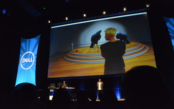 Jason Gholston wears headset near augmente-reality video call screen as Kumar Kaushik looks on from VRLA 2018 stage