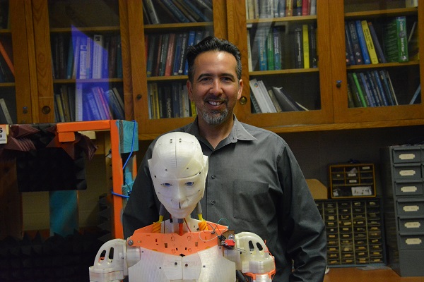 Walter Martinxz smiles as he stands behind his Evo robot