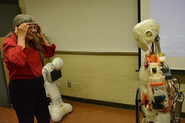 Reporter Dot Cannon smiles as Evo robot moves in responseto her brain waves