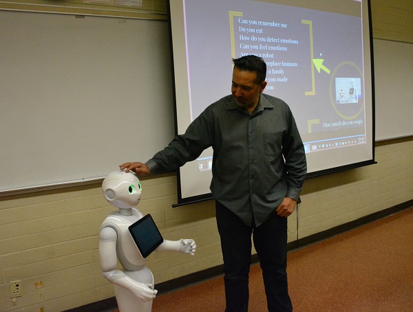 Walter Martinez of CSULB touches Pepper robot's head