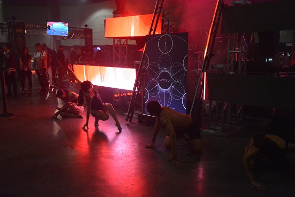 Dancers perform on show floor around Mezo temple in red laser lights