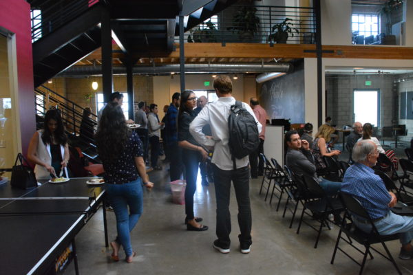 Audience and standees wait for "Demo Day" presentation