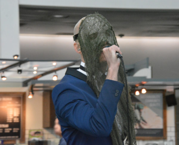 Singer Ban Sidh wears chest-long gray-green mask as he sings at ScareLA.