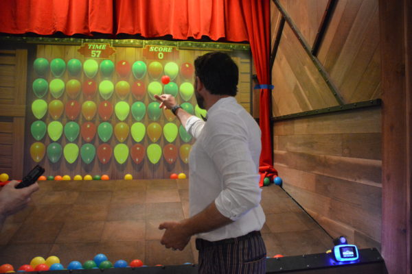 Two Bit Circus™ co-founder Brent Bushnell tosses a ball at a digital "balloon" in Micro Amusement Park™