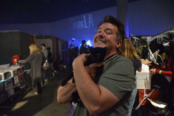 Kitty Bungalow staffer holds cute black kitten at ScareLA™2018