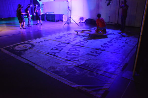 ScareLA 2018 attendee rids giant Ouija planchette on a giant board