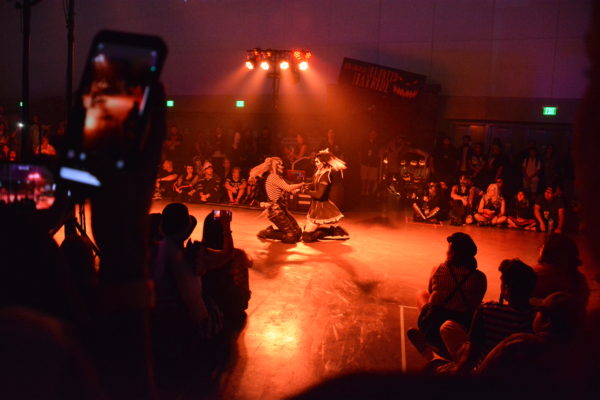 Two female sliders whirl in a circle on their knees with their hands joined at ScareLA 2018