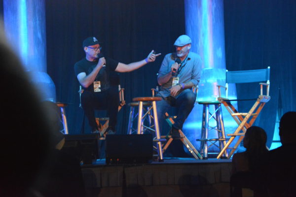 Universal Studios Creatie DIrector John Murdy speaks to audiences as Chris williams listens during "Halloween Horror Nights" reveal at ScareLA™ 2018