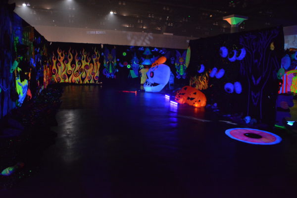 room partitions with creepy skulls and fluorescent blacklight mural at ScareLA™ 2018