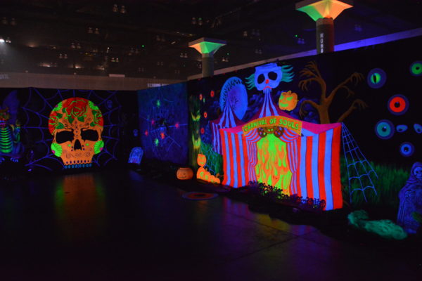 Blacklight "Dia de los Muertos" skull and spooky cats in fluourescent painting on wall at ScareLA™ 2018