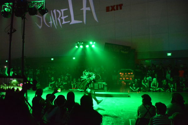 Decayed Brigade zombie xlider runs past audience as a green light floods the stage area during sliders show at ScareLA™ 2018