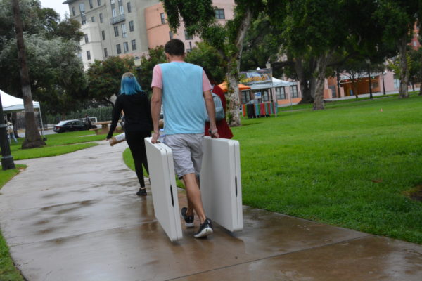 Exhibitors walk through rainy Central Park with tables for San Gabriel Valley Pride 2018