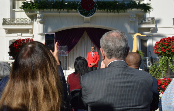 2019 Tournament of Roses President Gerald Freeny stands onstage before audience as one member photographs him on her phone during Grand Marshal announcement