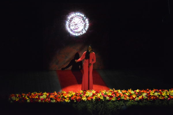Female vocalist in a red dress delivers her interpretation of "The Impossible Dream" at the Rose Queen coronation ceremony