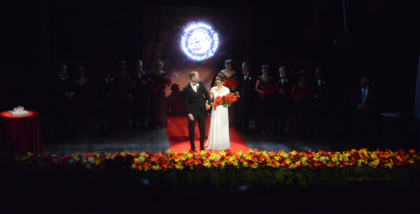 2019 Rose Queen Louise Deser Siskel center stage on her father's arm, surrounded by her Royal Court