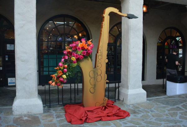 Wooden cutout saxophone logo overflows with flowers at Rose Queen reception, Pasadena Playhouse