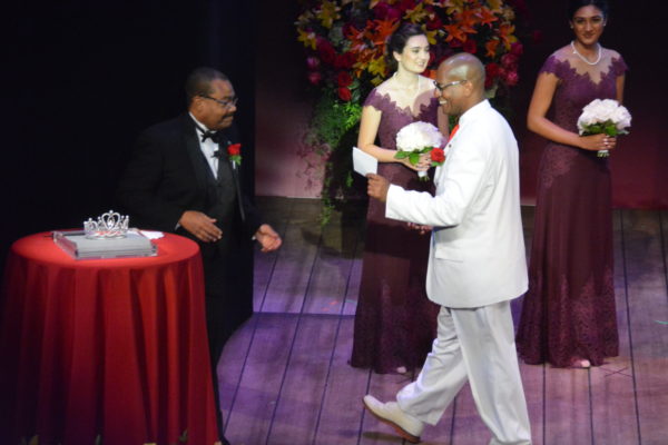 2019 Queen and Court Committee Chair Craig Washington approaches President Freeny with "the envelope"