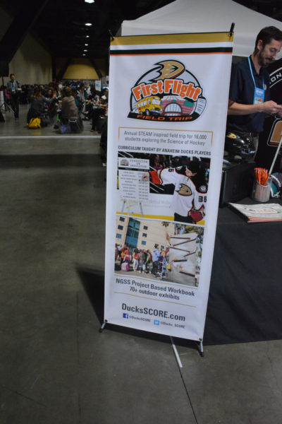 Banner advertising "First Flight Field Trip" on the California STEAM Symposium exhibit floor