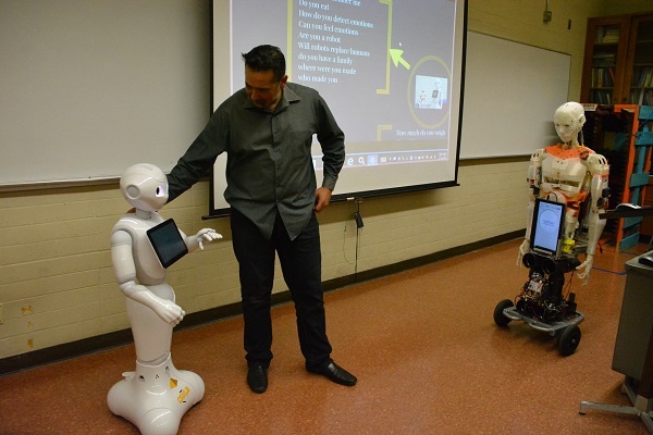 Roboticist Walter Martinez with Pepper and Evo robots in CSULB laboratory