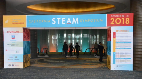 California STEAM Symposium entrance arch with attendees heading for the escalators